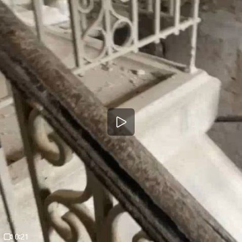 Denkmaltreppe: Entfernen vieler Schichten alter Farbe und Rost von den Handläufen und Geländern der Treppe und Reinigen der Stufen der Steintreppe.